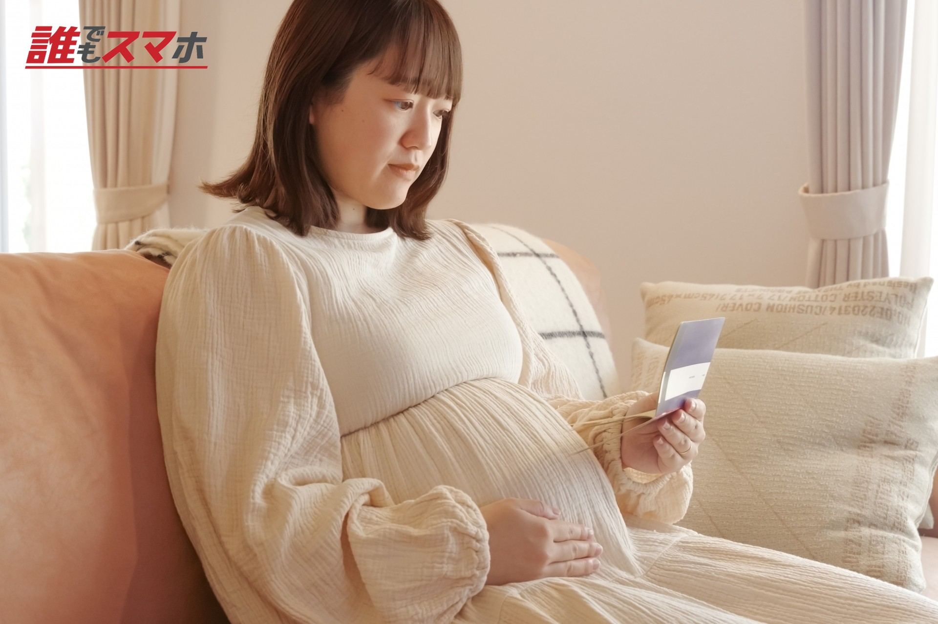 通帳を見る妊婦