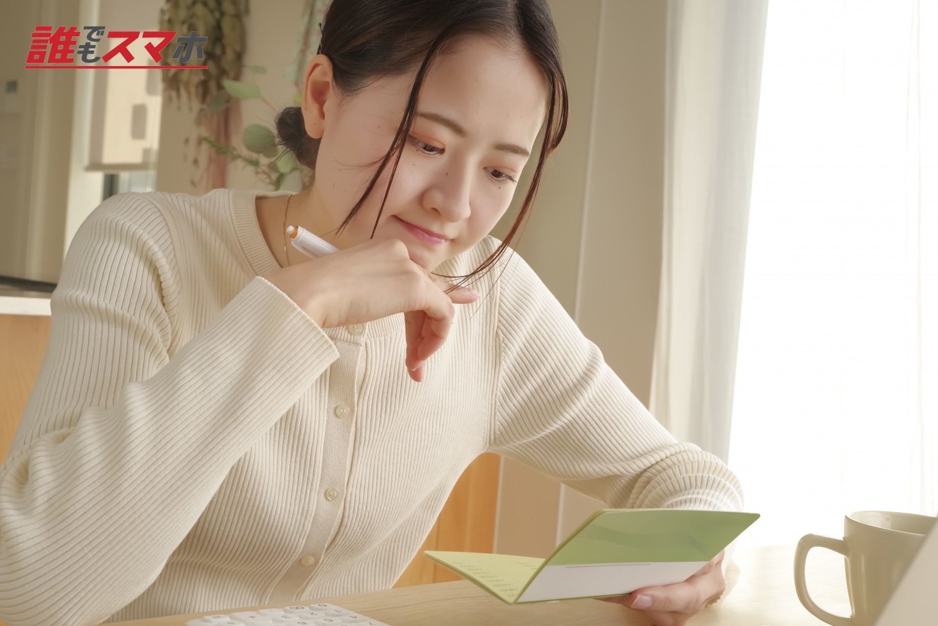 通帳を見て考える女性