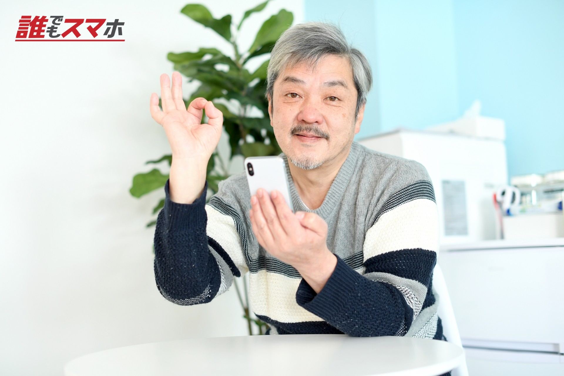 OKサインを出してスマホを操作する男性