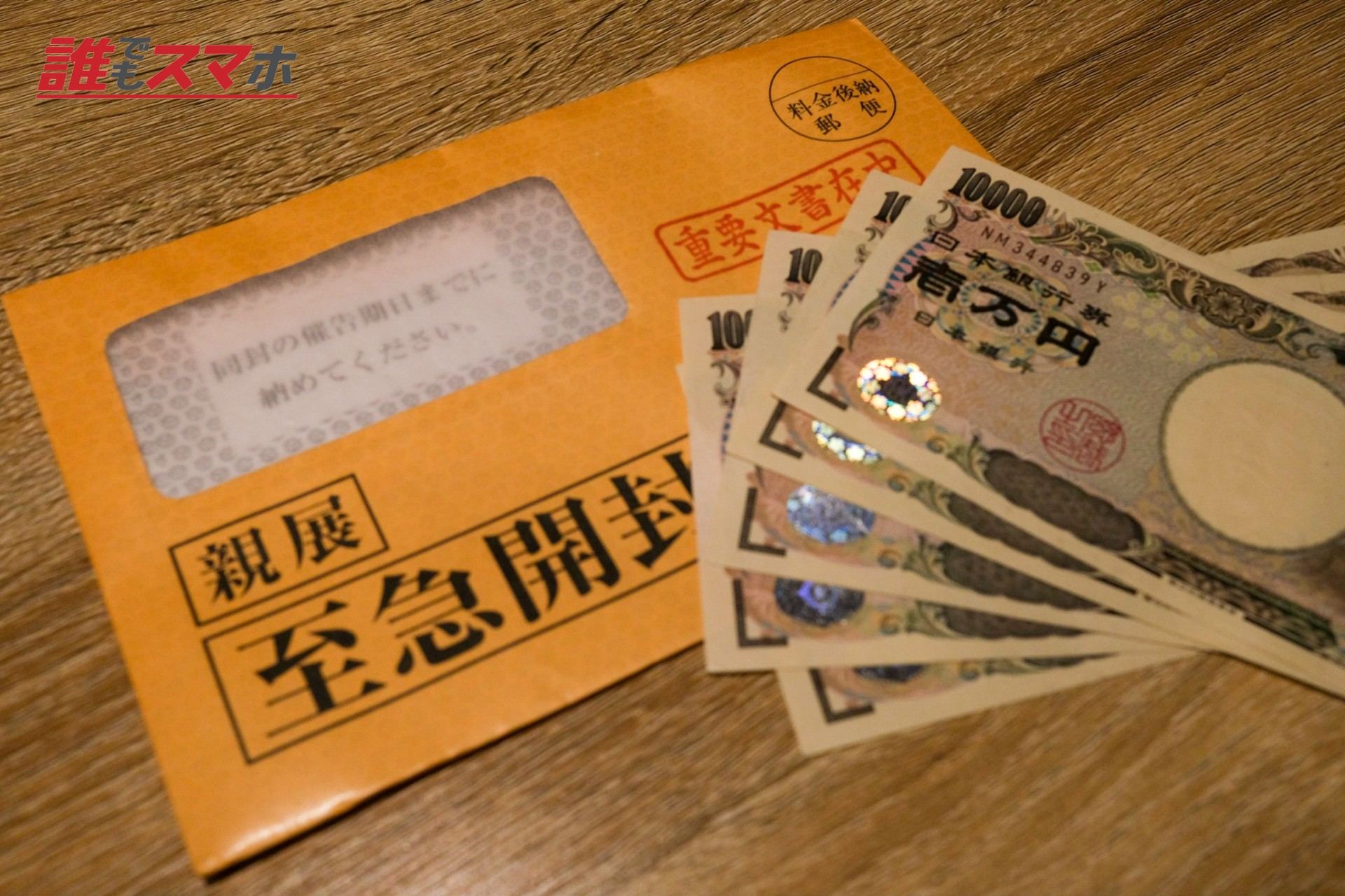 督促状の封筒と一万円札