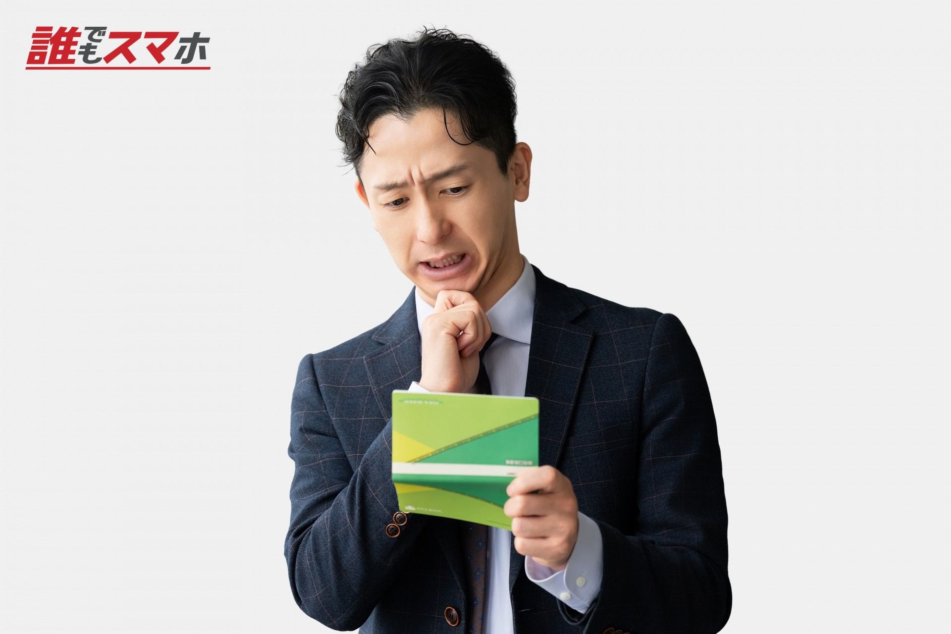 通帳を見て悩む男性