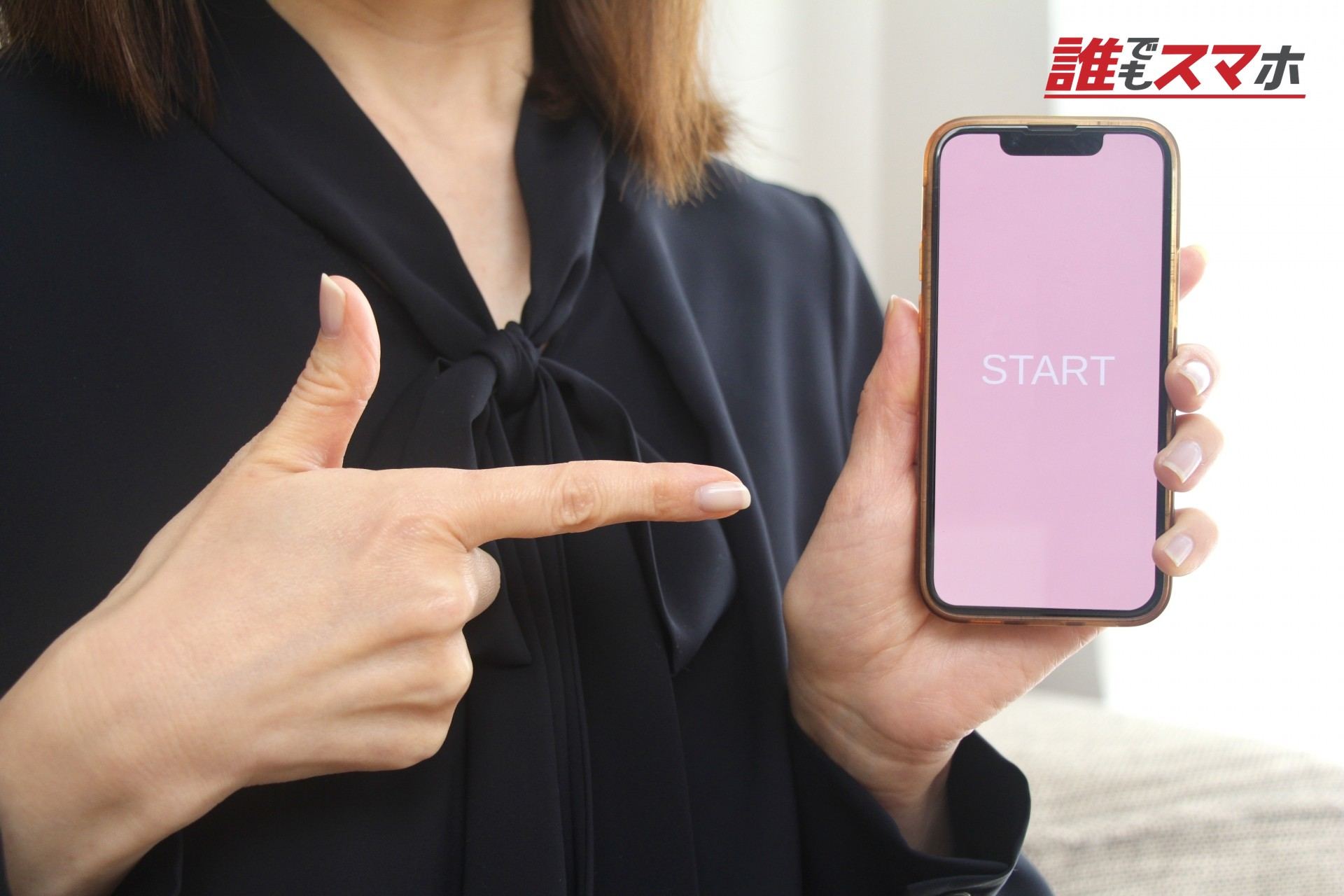スマホを指さす女性