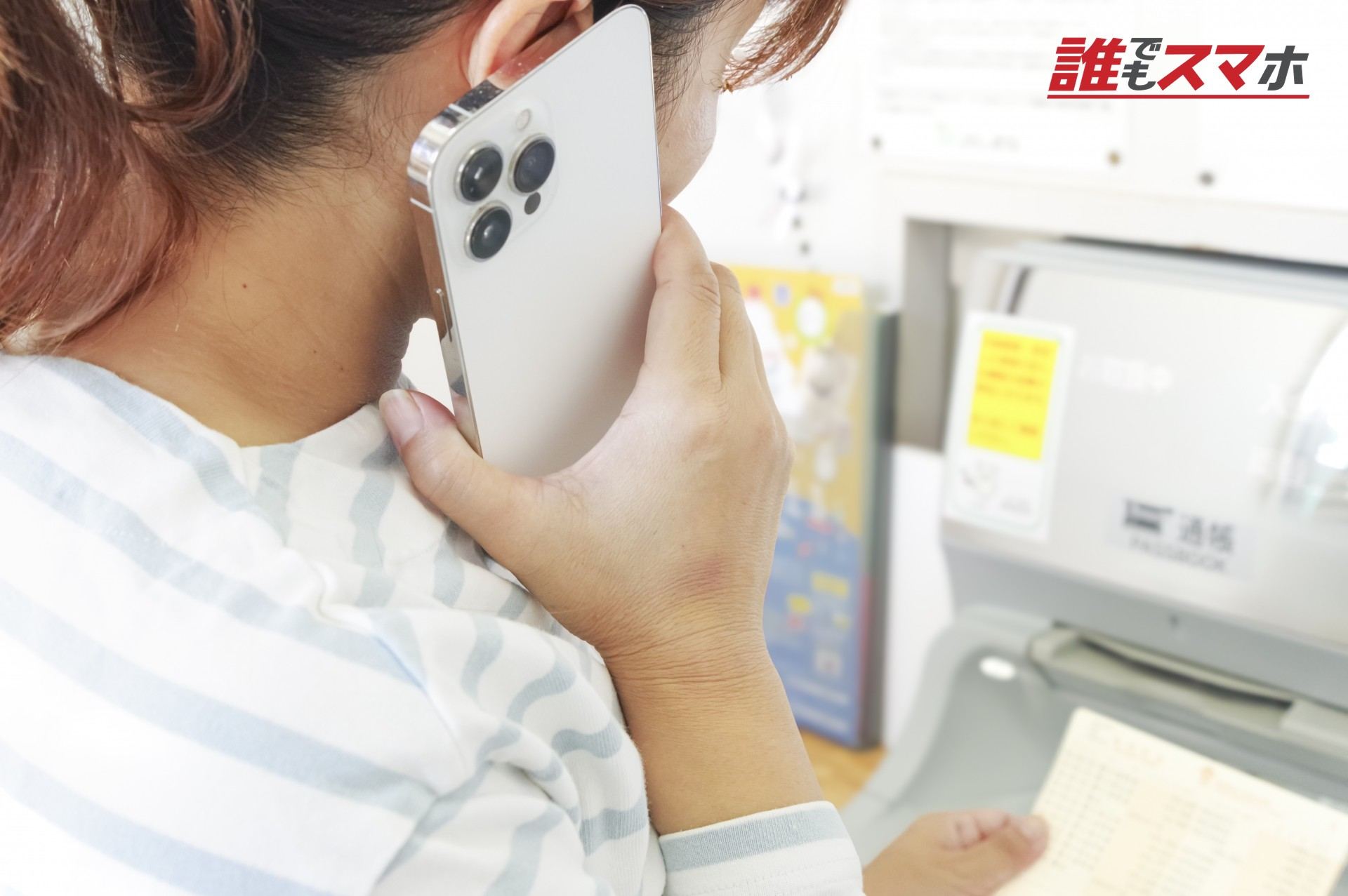 通話しながら銀行ATMを操作する女性