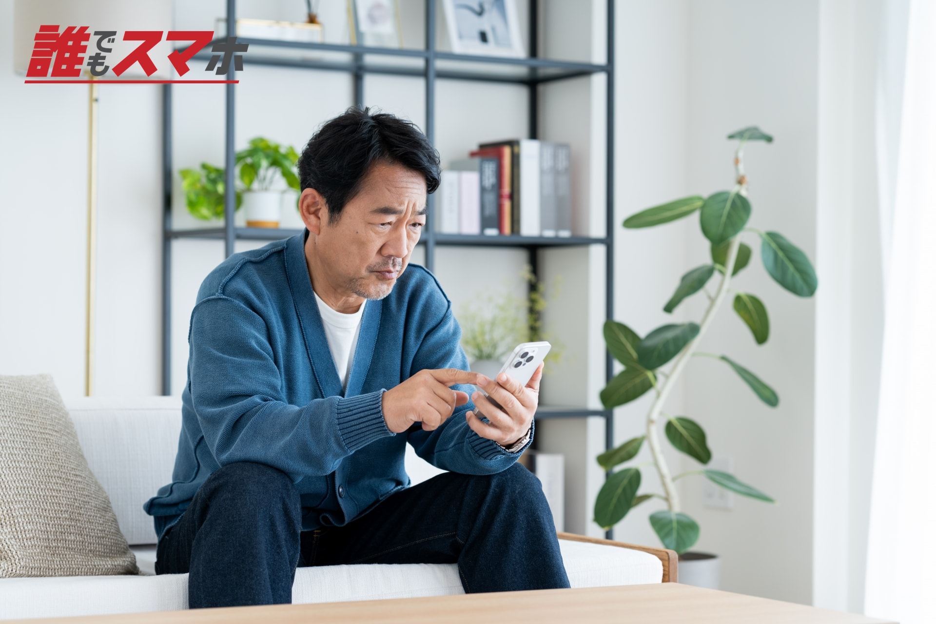スマートフォンを前に悩む男性