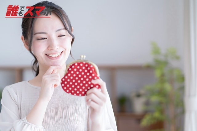 小銭入れを持つ笑顔の女性