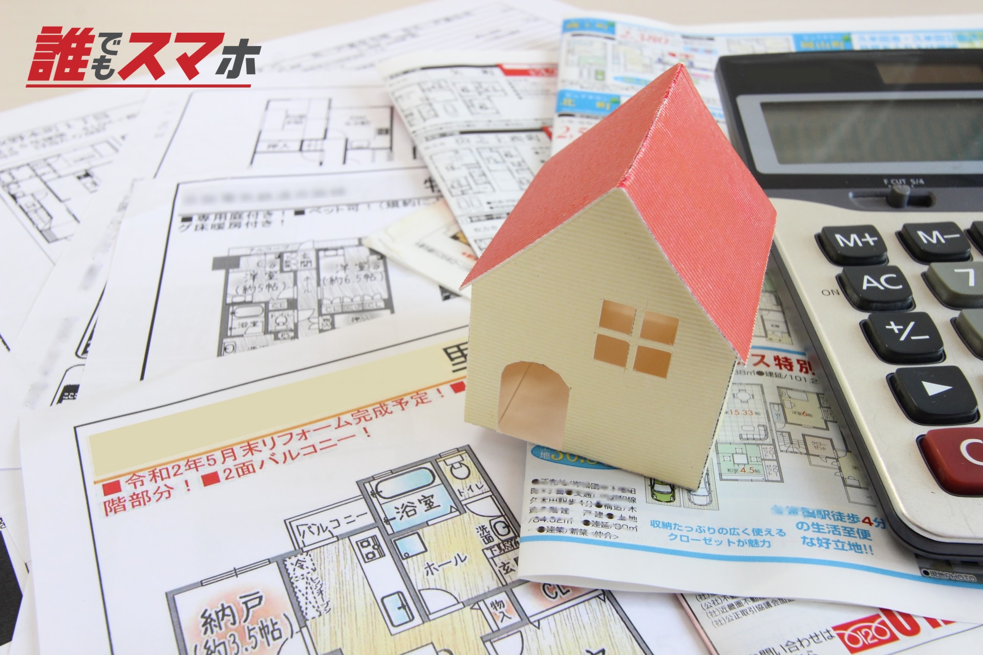 住宅資料と家の模型と電卓