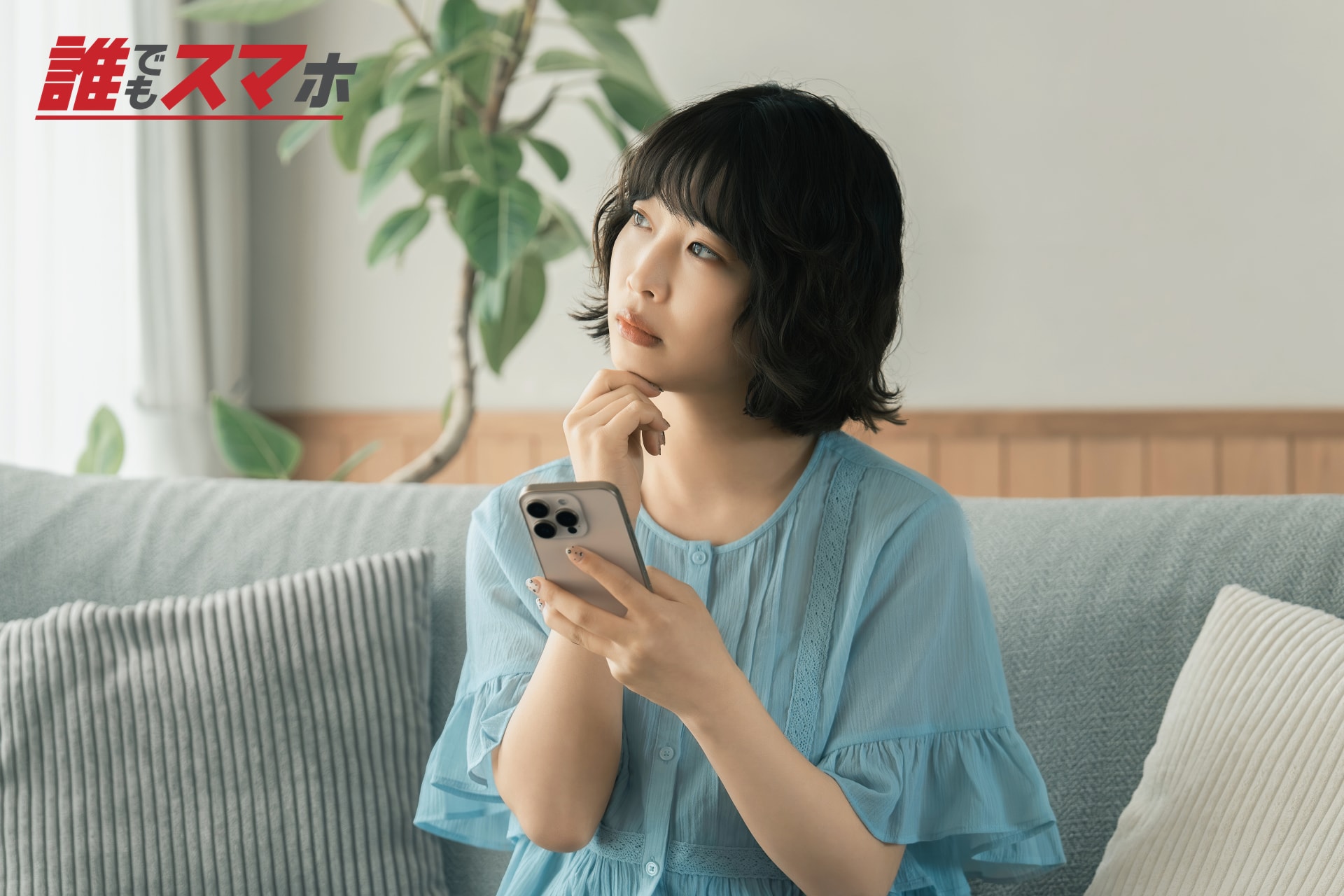 スマートフォンを手に考える女性