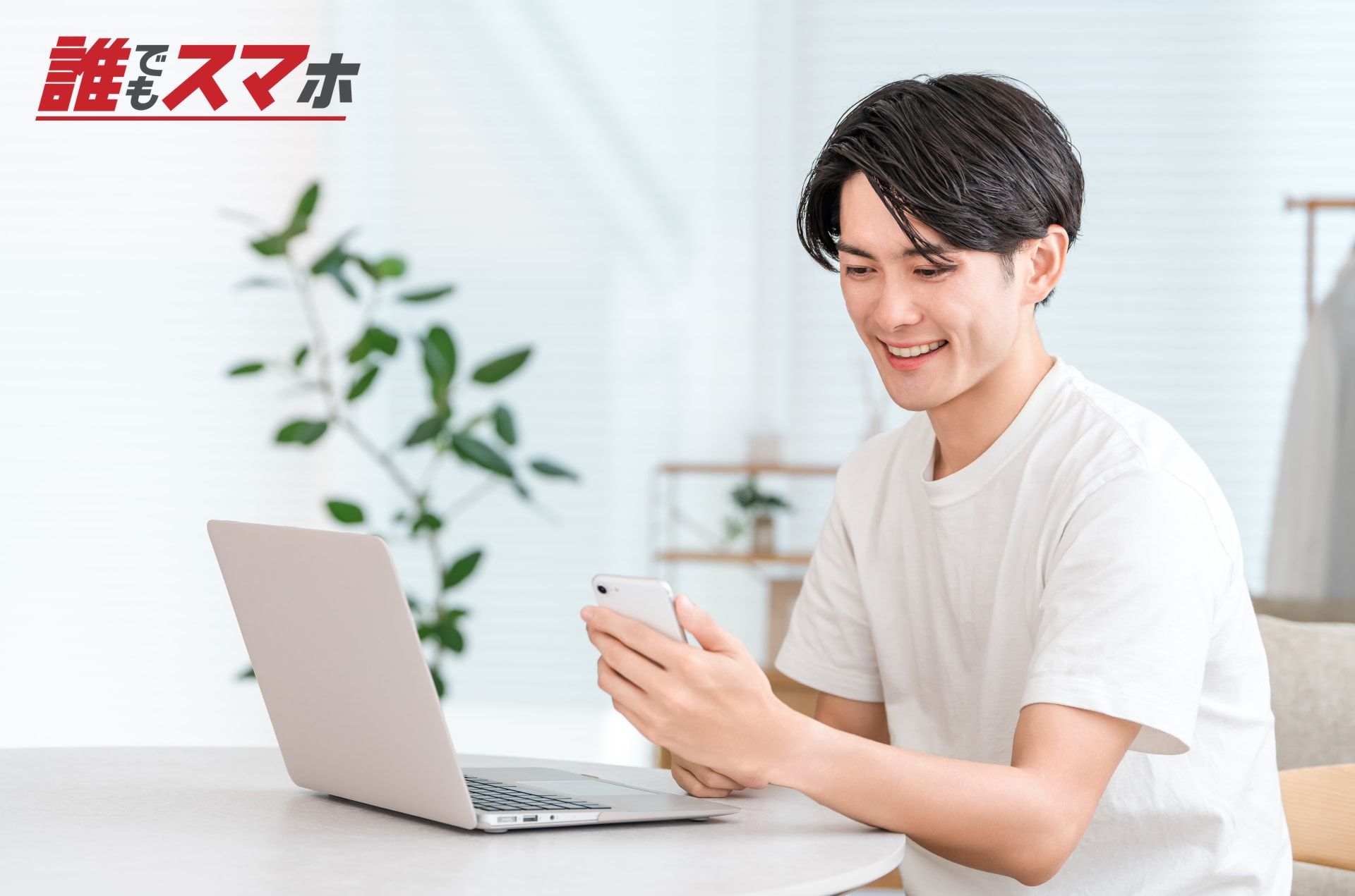 パソコンとスマートフォンを使う男性