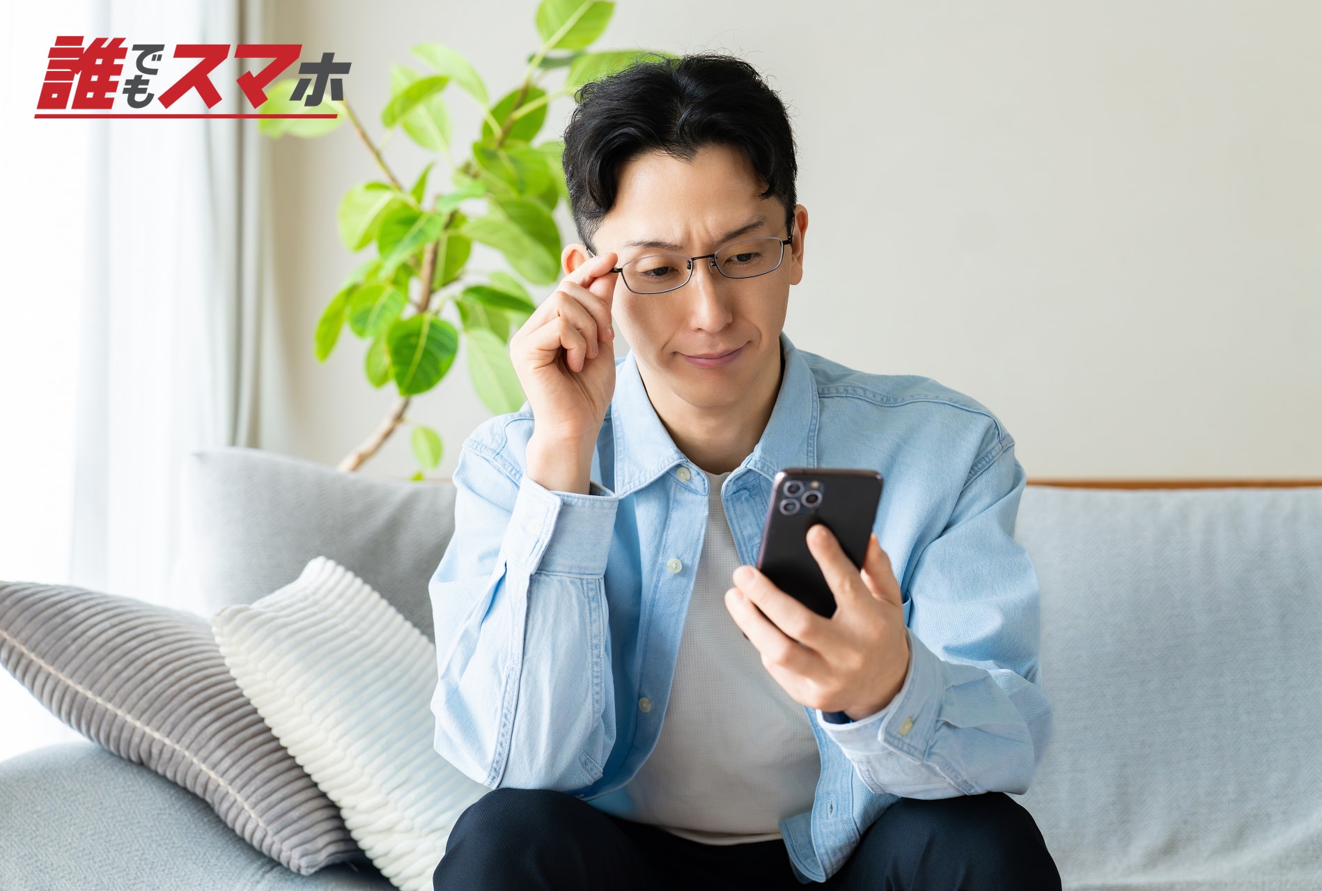 スマートフォンを見て考える男性