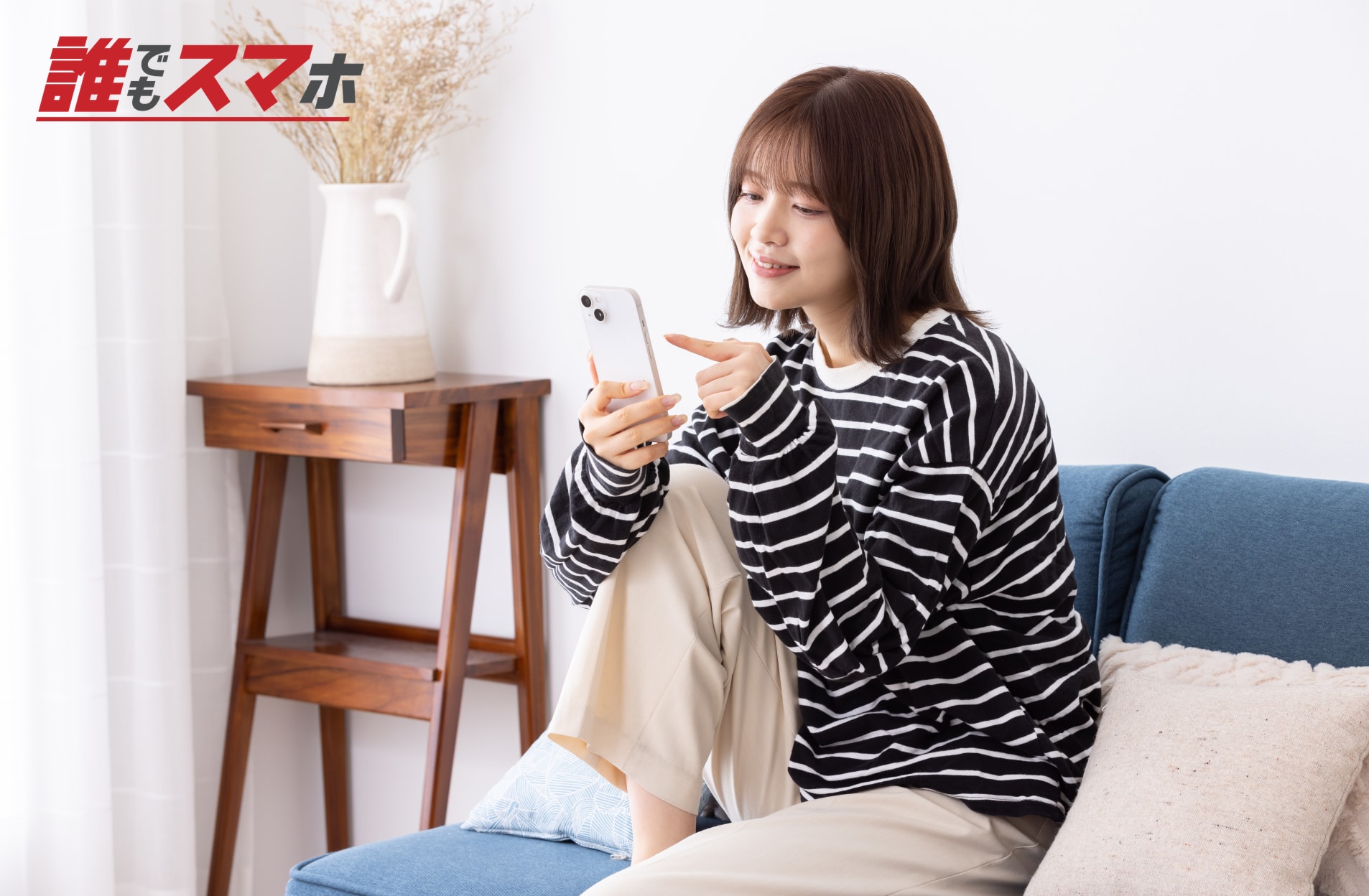 ソファでスマートフォンを見る女性